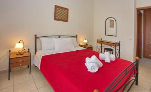 a bedroom with a red bed with towels on it at To Pithari in Skiros
