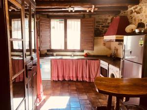 een keuken met een wastafel en een koelkast bij Casa ideal para grupos, Rustic Oh in Chert