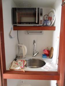 a kitchen counter with a sink and a microwave at villa Getty in Cala en Forcat +27 photos