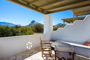 a balcony with a table and chairs and a view of mountains at To Pithari in Skiros