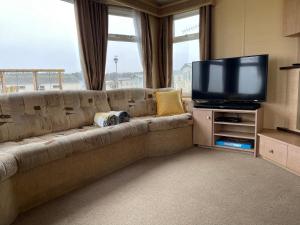 a living room with a couch and a television at The Westmorland in Eyemouth