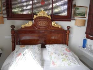 a bed with a wooden headboard in a bedroom at villa Getty in Cala en Forcat