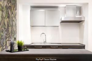 a kitchen with white cabinets and a sink at Suite 14, Terre Marine in Monterosso al Mare