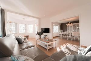 ein Wohnzimmer mit einem Sofa und einem Tisch in der Unterkunft Villa Promenade - luxuriously apartment for 8 people in Nieuwpoort