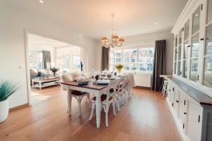 een keuken en eetkamer met een tafel en stoelen bij Villa Promenade - luxuriously apartment for 8 people in Nieuwpoort