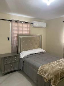 卡羅利納的住宿－Hermosa casa，一间卧室配有一张床、一个梳妆台和一扇窗户。