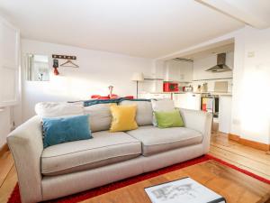 uma sala de estar com um sofá com almofadas coloridas em Lantern Cottage em Rye