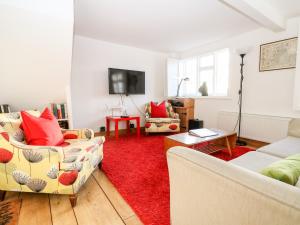 uma sala de estar com dois sofás e um tapete vermelho em Lantern Cottage em Rye