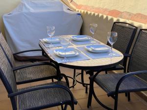 a table with plates and wine glasses on it at Duquesa village El Hacho in Manilva