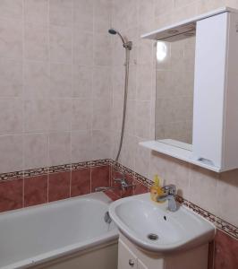 y baño con lavabo y bañera. en Двухкомнатная квартира с кухней студией Бровары. en Brovary