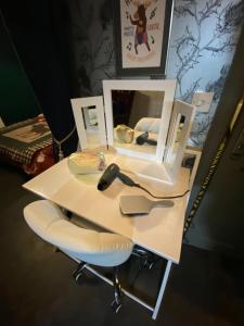 a white desk with a mirror and a chair at Taigh Neonach in Watten
