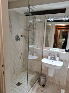 a bathroom with a glass shower and a sink at Suite del Mercante in Mantova
