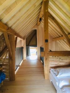 a attic room with a bed and a wooden ceiling at Boerderaaj vakantiewoning in Bilzen