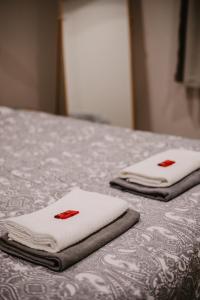 two white towels sitting on top of a bed at Central and Cozy in Brussels in Brussels