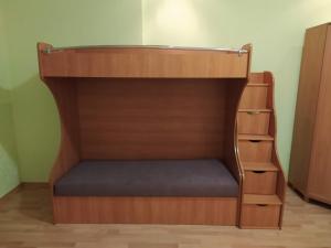 a bunk bed with a bench in a room at Двухкомнатная квартира с кухней студией Бровары. in Brovary