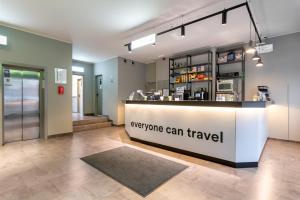 a restaurant with a counter with a sign that says everyone can travel at a&o Hamburg Hammer Kirche in Hamburg
