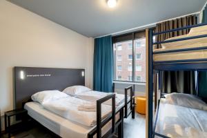 two bunk beds in a room with a window at a&o Hamburg Hammer Kirche in Hamburg