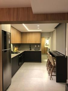 a kitchen with a refrigerator and a table and chairs at Apto Pé na Areia - Centro de Balneário Camboriú in Balneário Camboriú