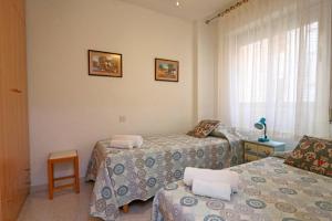 een kamer met 2 bedden en een raam bij 058 - Parque y Playa 002 - comfortHOLIDAYS in Santa Pola
