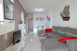 een woonkamer met een bank en een televisie bij 058 - Parque y Playa 002 - comfortHOLIDAYS in Santa Pola