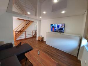 a living room with a couch and a flat screen tv at Monteurwohnung - Handwerkerwohnung in Pfungstadt