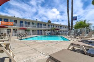 una piscina frente a un hotel con sillas y un edificio en Motel 6-Westminster, CA - South - Long Beach Area, en Westminster