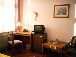 
a room with a desk and a tv at Haus am Pfaffenteich in Schwerin

