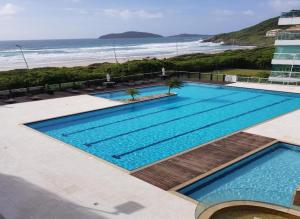 una vista aérea de una piscina junto a la playa en Santinho - Frente para Mar, Pé na Areia, Dois Quartos, en Florianópolis