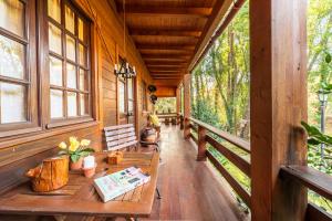 een veranda van een hut met een tafel en ramen bij Riba Rio - Unique Nature Spot in Ponte de Lima