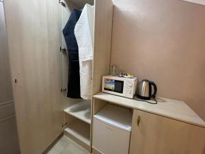 a small kitchen with a microwave on a counter at Guest house Vasco Da Gama in Tver