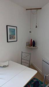 um quarto branco com uma mesa e uma cadeira em Studio du Cairn em Wimereux