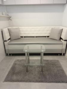 - un canapé blanc avec deux oreillers et une table basse en verre dans l'établissement Modern fresh-new appartment near the park Sofievka, à Ouman