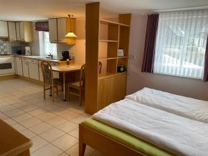 Cet appartement comprend une chambre avec un lit et une cuisine avec une table. dans l'établissement Ferienhaus Leeb, à Patergassen