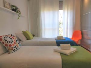 ein Hotelzimmer mit 2 Betten und einem orangenen Stuhl in der Unterkunft Bnbook Trilo Mind Rho Trilocale con 2 camere e 2 bagni in Rho