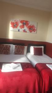 dwa łóżka siedzące obok siebie w pokoju w obiekcie All Seasons Guest House w mieście Great Yarmouth