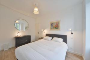 1 dormitorio con 1 cama blanca grande y espejo en La Maison d'Hera, en Vierzon