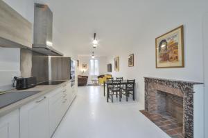 a kitchen with a fireplace and a living room at La Maison d'Hera in Vierzon