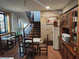 a dining room with a table and chairs and a staircase at Albergue Villa San Clemente in Tui