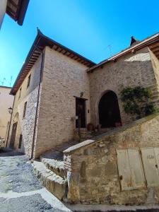 um edifício de tijolos com uma porta e passos em frente em Casa Vacanze del Console em Bevagna