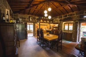 a kitchen and dining room with a table and chairs at Casas da Fraga 2020 in Ribeira de Pena