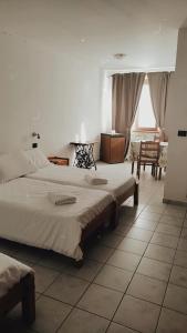 um quarto de hotel com duas camas e uma mesa em Agriturismo San Giuliano dei fratelli Giai em Susa