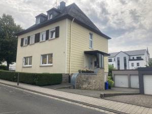 a large yellow house on the side of a street at Ferienwohnung KaMa in Bitburg