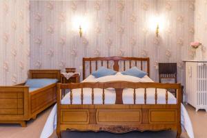 two wooden beds in a bedroom with a wallpaper at Le Clos de Tweed in Tanlay