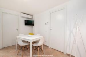 een witte eetkamer met een witte tafel en stoelen bij Rio Bello in Riomaggiore