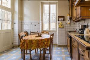 a kitchen with a table with chairs and a tableablish at Le Clos de Tweed in Tanlay