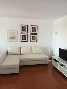 sala de estar con sofá blanco y TV en T1 Praia do Vau / Estrela do Vau en Portimão