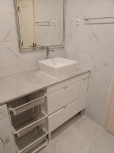 ein weißes Badezimmer mit einem Waschbecken und einem Spiegel in der Unterkunft T1 Praia do Vau / Estrela do Vau in Portimão