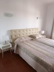 1 dormitorio con 1 cama grande y pared blanca en T1 Praia do Vau / Estrela do Vau en Portimão