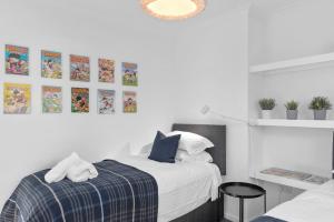een witte slaapkamer met een bed met een blauwe deken bij MyCityHaven - The Grove. Superb house sleeps 8 in Avonmouth