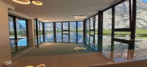 Habitación con vistas a una piscina con ventanas. en Hotel Comfort Erica Dolomiti Val d'Adige, en Salorno